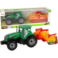 Zaļš traktors ar oranžu kultivatoru