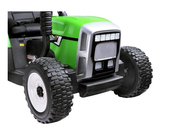 Liels elektriskais traktors ar piekabi, zaļš